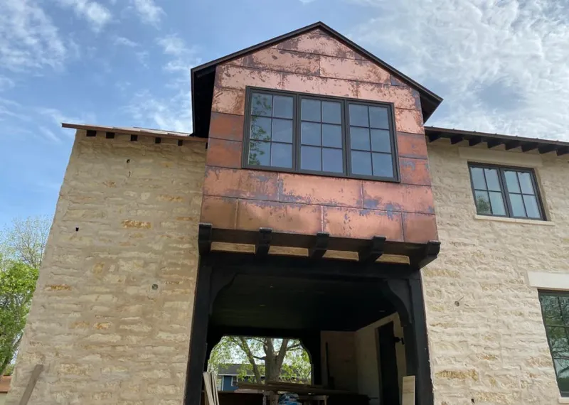 Copper metal panel facade on a stone building for Roof Repair in Covedale
